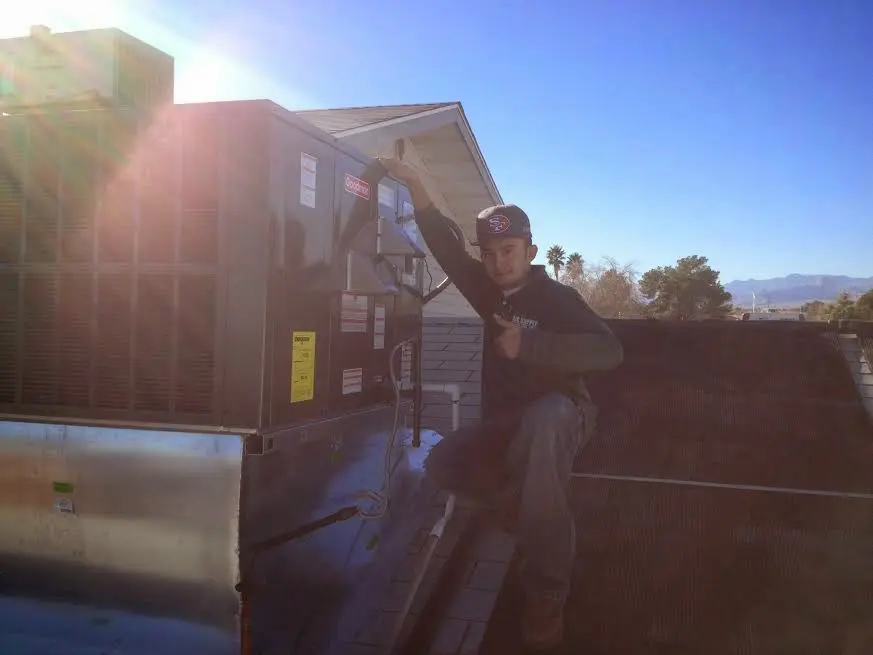 HVAC technician performing HVAC Inspection on a rooftop unit in White City